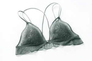 Dettaglio del reggiseno a triangolo in pizzo verde salvia con motivi floreali e gancio frontale