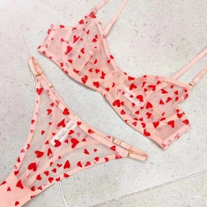 Détail d'ensemble de lingerie en tulle rose avec motifs cœurs et étiquette