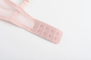 Detail view of the breathable mesh back strap with pink four-row triple hook-and-eye closure