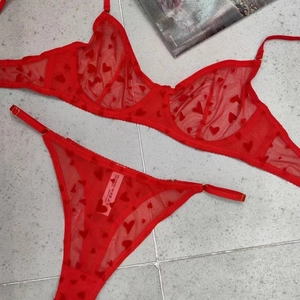 Détail macro d'un ensemble de lingerie en dentelle rouge avec motif cœur et étiquette