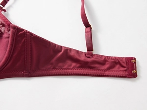 Detailed macro view of wine red bra featuring wide side wings and adjustable back straps