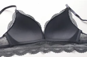 Detail shot of delicate eyelash lace trim and sheer polka dot mesh on the dark grey bra