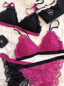 Flat lay of floral lace triangle bra set in black and magenta with baby embroidery detail