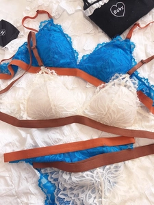 Flat lay of lace bralette sets in royal blue and cream white with floral mesh details