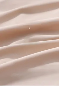 Détail macro du tissu sans couture respirant montrant une élasticité et texture douce