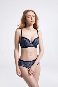 Detail of dark blue lingerie set with geometric diamond pattern and gold metal buckles