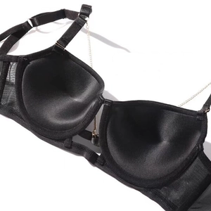 Detail of black bra showing silk inner cups and decorative gold chain straps