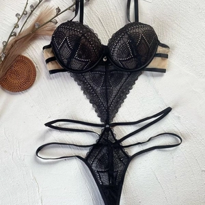 Close-up of black lace bodysuit featuring intricate patterns and mesh detailing