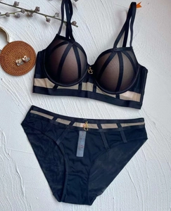 Detail of mesh bra and panty set with gold G-logo hardware and crisscross geometric lines