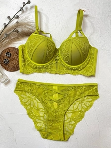 Detailed flat lay of neon green lace lingerie set with push-up bra and strappy panties