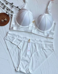White push-up lingerie set with mesh panels and contrast lace detail on textured background