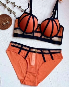 Detail of orange and black push-up lingerie set with lace texture and strap accents