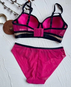 Detail view of pink lace bra set featuring back multi-strap cross design and striped mesh