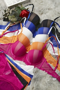 Detail of colorful lace lingerie sets with metal rings on soft faux fur background