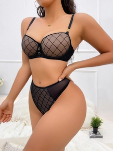 Macro shot of black mesh geometric pattern lingerie set with gold ring hardware details