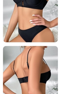 Close-up of black seamless push-up bra with adjustable thin straps and metal buckle