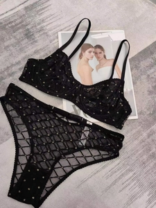 Dettaglio del set di lingerie in pizzo a rete nero con eleganti pois dorati stampati