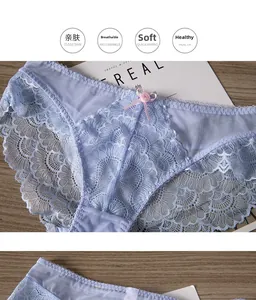 Detailed view of blue lace panties with floral embroidery and pink bow on wood background