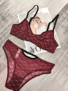 Dettaglio completo di set intimo in pizzo bordeaux con ricami dorati e spalline nere
