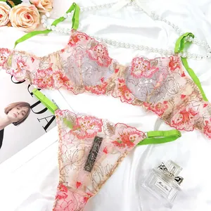 Detail of floral lace lingerie set with pink embroidery and green contrast straps