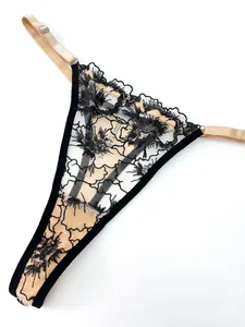Detail of black floral lace thong with sheer skin-tone lining and delicate mesh texture
