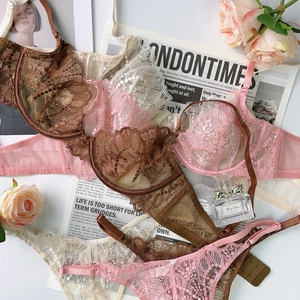Detailed flat lay of lace lingerie sets in brown and pink with floral embroidery