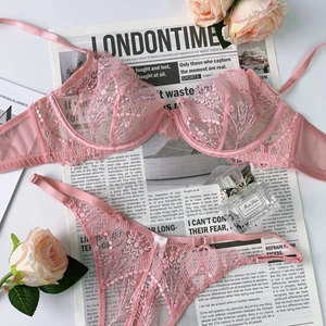 Detailed flat lay of pink floral lace lingerie set with elegant rose and perfume accents