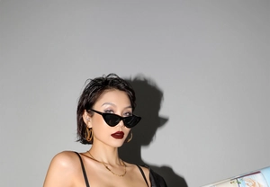 Gros plan sur des lunettes œil-de-chat avec boucles d'oreilles logo et collier doré