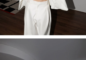 Détail du pantalon de costume blanc à taille haute et jambe large avec plis élégants