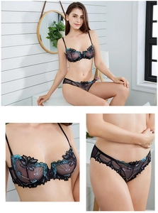 Detail of floral embroidery on black sheer mesh bra set with intricate lace textures