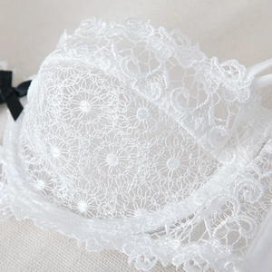 White lace bra with daisy embroidery and black bow detail in a half cup design