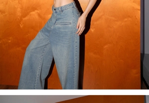 Détail d'un jean bleu clair à taille haute, jambe large, lavage vintage et texture denim