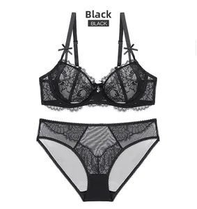 Detailed close-up of a black floral lace lingerie set with bow accents on white background