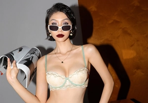 Détails du soutien-gorge en dentelle beige avec bordure en satin vert et armature de soutien