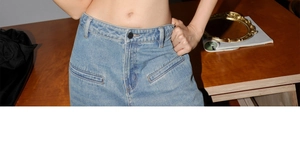 Détail du jean taille haute bleu clair avec délavage rétro et boutons en métal