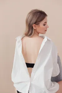 Détail d'une bralette dos nu en dentelle noire à fines bretelles présentée sur un mannequin