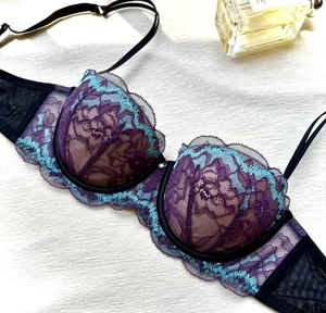 Détail de soutien-gorge en dentelle violette, broderie bleue, tulle noir et strass