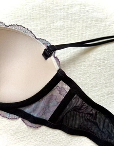 Détail du soutien-gorge en dentelle contrastée avec bonnets beige et broderie violette