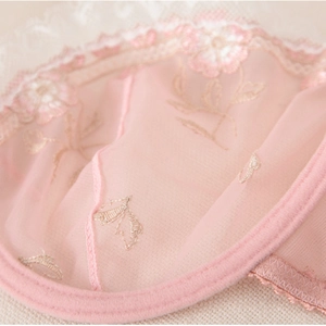 Détail du tissu en maille rose avec broderie florale et dentelle pour lingerie fine