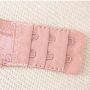 Détail d'un soutien-gorge en dentelle rose avec agrafes à trois rangs et couture fine