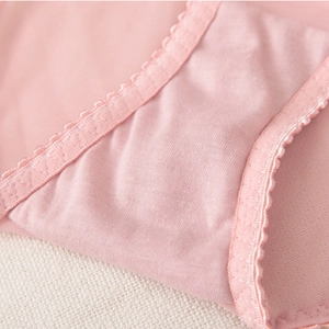 Gros plan sur la culotte en dentelle rose avec entrejambe double couche et bords festonnés