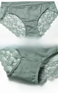 Detailed macro view of gray-green lace floral patterns and soft cotton inner lining of panties