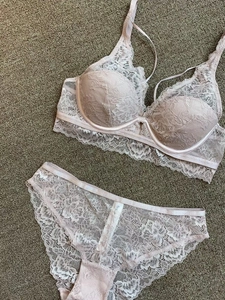 Flat lay of light pink French lace lingerie set featuring underwired bra and matching briefs