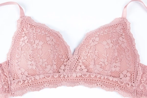 Detailed close-up of pink floral lace texture and adjustable straps on wireless bra