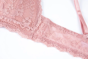 Detail of rose pink lace bra featuring intricate floral patterns and scalloped edges