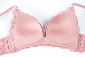 Detail view of pink lace bra with silky cups and delicate mesh wings for women