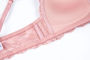 Detailed close-up of pink lace bra wings with soft side boning and size B75 tag