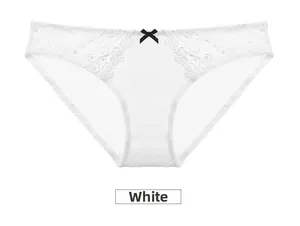 Detailed view of white floral lace embroidery and small black bow on silky panties