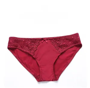Detail of dark red lace underwear with floral crochet patterns and a small silk bow