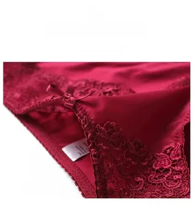 Detail of dark red lace panties featuring elastic waist and a silk satin bow accent